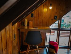 an attic room with a desk and a chair at Recanto AlceNegro in Miguel Pereira