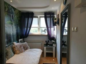 a small bedroom with a bed and a window at Apartamenty na doby in Siedlce