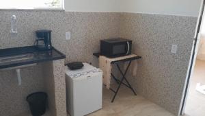 a small kitchen with a television on a table with a refrigerator at Mini Casa Monte Cielo in Miguel Pereira