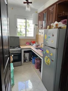 a kitchen with a white refrigerator and a stove at Forest near to the beach امام المستشفى الجامعي طنجة in Daidatz