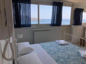 Un dormitorio con una cama y vista al mar. en Taormina loview, en Giardini Naxos