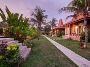 einen Weg zu einem Haus mit Palmen in der Unterkunft Kanchana Cottages in Uluwatu