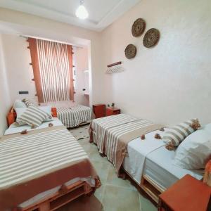 a room with two beds and a window in it at Azour House in Taghazout