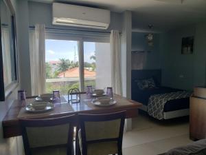 ein Zimmer mit einem Tisch und ein Schlafzimmer mit einem Bett in der Unterkunft DB Tower Vacation Rental in Belize City