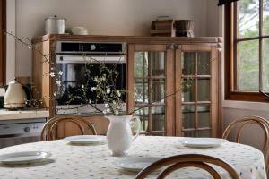 Una cocina con una mesa con un jarrón de flores encima. en French Cottage- 2 bedrooms with huge spa, en Daylesford 9 fotos más