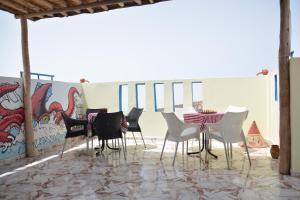 a group of chairs and a table in front of a wall at Azour House in Taghazout