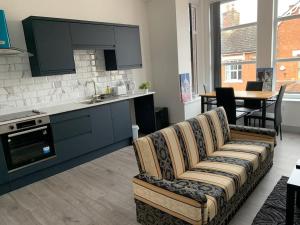 a living room with a couch and a kitchen at Greater grace in Desborough