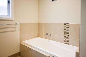 a bathroom with a bath tub and a window at Rosebud Beach House in Rosebud +9 photos