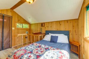 a bedroom with a bed in a room with wooden walls at Cabin on 5 Acres in Port Angeles with Fire Pit! in Port Angeles