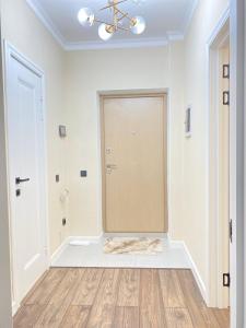 a white room with a door and a wooden floor at Б241 Нурлы-жол in Promyshlennyy