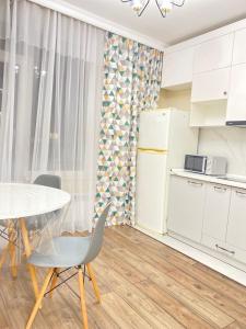 a kitchen with a table and a table and chairs at Б241 Нурлы-жол in Promyshlennyy