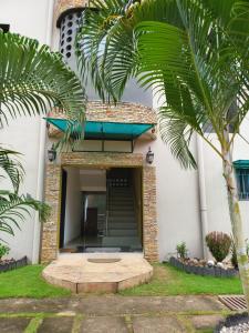 a building with a palm tree in front of it at Résidence ephrata in Cocody
