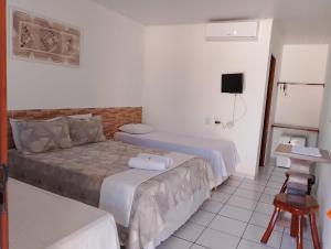 a hotel room with two beds and a television at Torre do Sol in Praia do Frances +22 photos