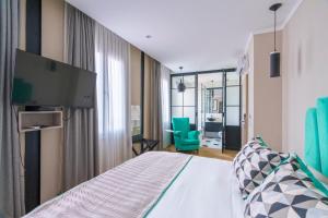 a hotel room with a bed and a tv at Rendez Vous Hotel Buenos Aires in Buenos Aires