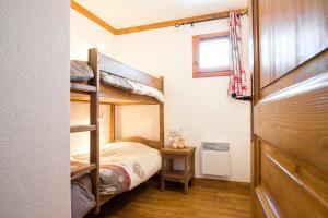 ベッサンにあるRésidence le Clos Vanoiseのベッドルーム1室(二段ベッド2台、窓付)が備わります。