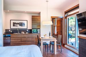 a kitchen and dining room with a table and chairs at Lakefront and Mountain View - Resort Studio in Lac-Superieur