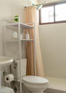a bathroom with a toilet and a sink and a window at Amaia Beach House in El Chirú +8 photos