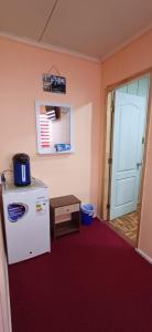 a kitchen with a refrigerator and a table and a door at Turismo FORTALEZA PATAGONIA in Puerto Natales