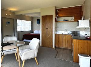 a small room with a kitchen and a bedroom at Ala Moana Motel in Paihia
