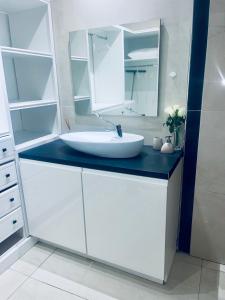 ein weißes Badezimmer mit Waschbecken und Spiegel in der Unterkunft La Villa Néoma in Saint-Pierre + 9 Fotos