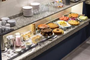 a buffet with cakes and pastries on a counter at Tripoli Sorocaba Hotel in Sorocaba