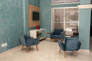 a living room with two chairs and a television at Tripoli Sorocaba Hotel in Sorocaba