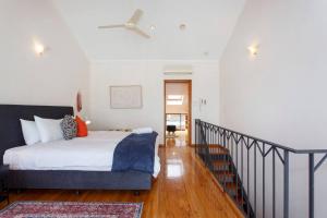 a bedroom with a bed with a ceiling fan at Bathers Beach Loft Rooftop Views in Fremantle