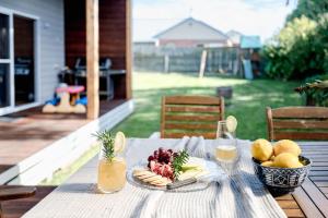 a table with a plate of food and a bowl of fruit at Loch House in Inverloch
