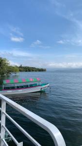 a boat sitting on the water next to a pier at Hotel Las Brisas in Catemaco
