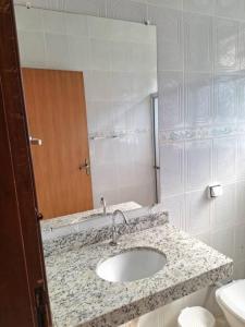 a bathroom with a sink and a mirror at Casa acolhedora para descanso in Brotas