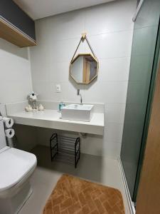 a bathroom with a sink and a toilet at Praia do Cabo Branco- FLAT DO BZ- 2 quartos in Tambaú