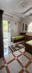 a room with two beds and a tiled floor at Villa Rose - Luxor in Luxor