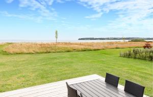 una terrazza in legno con tavolo e sedie in un campo di Holiday Home Vemmingbund Strandvej Broager I a Broager Altre 10 foto