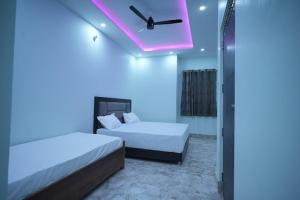 a room with two beds and a purple light at preferred hotel and restaurant in Roorkee