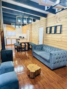 un soggiorno con un divano blu e un tavolo di Cabañas Aires de Huerquehue a Panguipulli