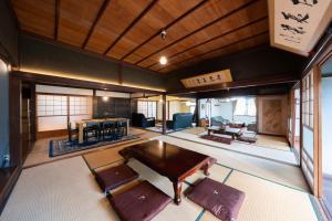倉敷市にある倉敷の宿Retreat KOBAYASHI 1棟貸切 1日1組限定 11LLDDK 520平米 102年前の伝説の建物 瀬戸内芸術祭2025 直島 美観地区 最大10名 駐車場3台 ベッド8台のテーブルと椅子が備わる客室です。