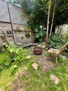 a garden with two chairs and a bench in the grass at Oasis Hollywood in Los Angeles