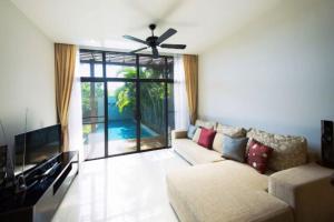 a living room with a couch and a large window at Вилла с бассейном на Най Харн, 3 спальни G7 in Rawai Beach