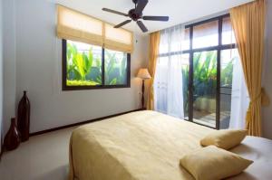 a bedroom with a bed with a ceiling fan and a window at Вилла с бассейном на Най Харн, 3 спальни G7 in Rawai Beach