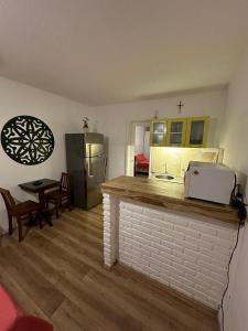 a kitchen with a counter with a refrigerator and a table at Flat Privativo Rua das Pedras in Búzios