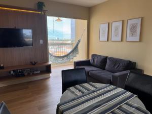a living room with a couch and a flat screen tv at Lindo 2 quartos a 4 min da orla in Aracaju