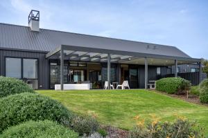 a black house with a lawn in front of it at Casa Nera I Private Properties in Yallingup