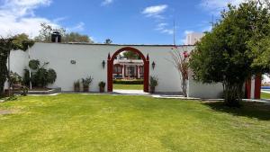 ein weißes Gebäude mit einem Bogen und einem Hof in der Unterkunft Hacienda de Pueblito Atotonilco in Banda + 5 Fotos