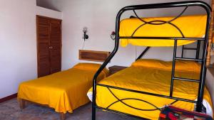 2 Etagenbetten in einem Zimmer mit gelber Bettwäsche in der Unterkunft Hacienda de Pueblito Atotonilco in Banda