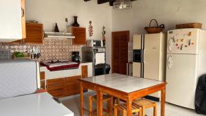 eine Küche mit einem Tisch und einem weißen Kühlschrank in der Unterkunft Hacienda de Pueblito Atotonilco in Banda
