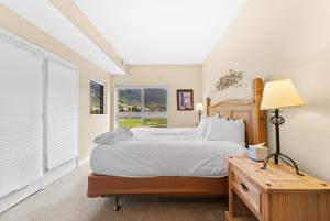 a bedroom with a bed and a table with a lamp at Greens at Copper 214 by Summit County Mountain Retreats in Copper Mountain
