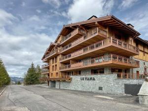 a large wooden building on the side of a street at Appartement neuf 3 chambres proche des pistes, parking et Wi-Fi - FR-1-565-108 in Les Allues