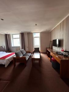 ウランバートルにあるZuut hotelのベッドとソファのあるホテルの部屋