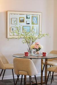 a dining room table with a vase of flowers on it at RiverWinds - Modern Charm Near Shenandoah National Park in Luray