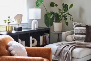 a living room with two chairs and a book shelf with plants at RiverWinds - Modern Charm Near Shenandoah National Park in Luray